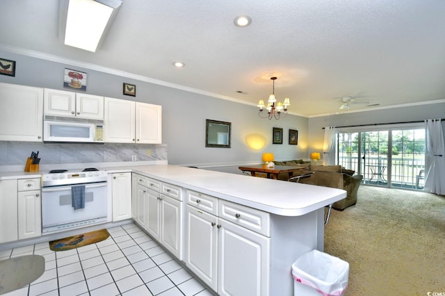 kitchen featuring white appliances, tasteful backsplash, kitchen peninsula, and ceiling fan with notable chandelier