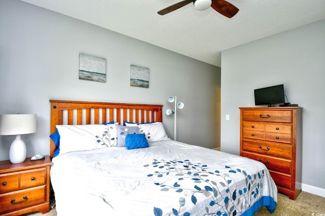 bedroom with light colored carpet, ceiling fan, and a textured ceiling