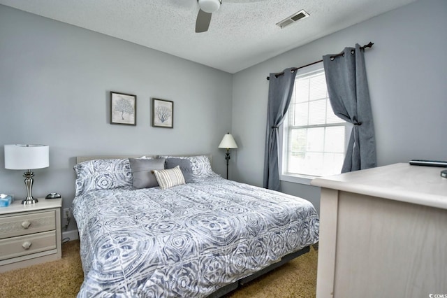 carpeted bedroom with a textured ceiling and ceiling fan