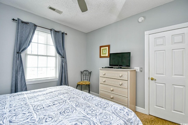 carpeted bedroom featuring a textured ceiling and ceiling fan