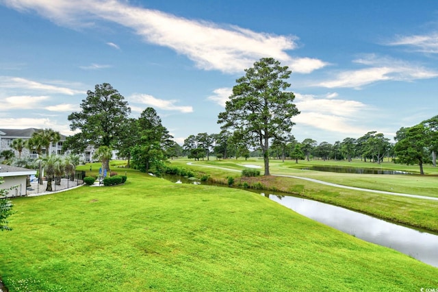 view of home's community featuring a lawn and a water view