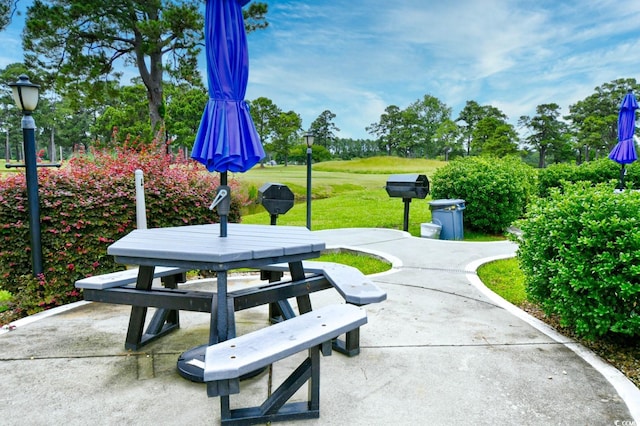 view of property's community featuring a patio area and a lawn