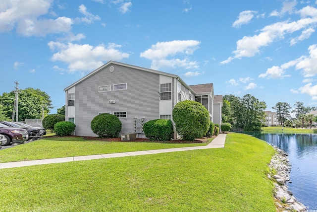 view of property exterior with a lawn and a water view