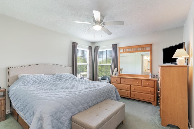 carpeted bedroom with ceiling fan and a textured ceiling