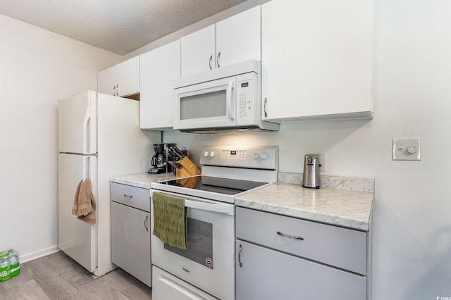 kitchen with gray cabinetry, light hardwood / wood-style floors, white appliances, and white cabinetry