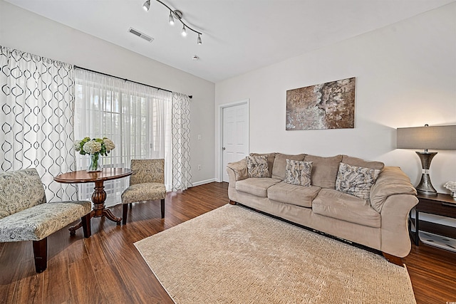 living room featuring dark hardwood / wood-style floors and rail lighting