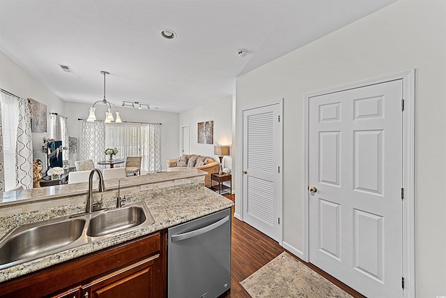 kitchen featuring dishwasher, decorative light fixtures, dark wood-type flooring, light stone counters, and sink