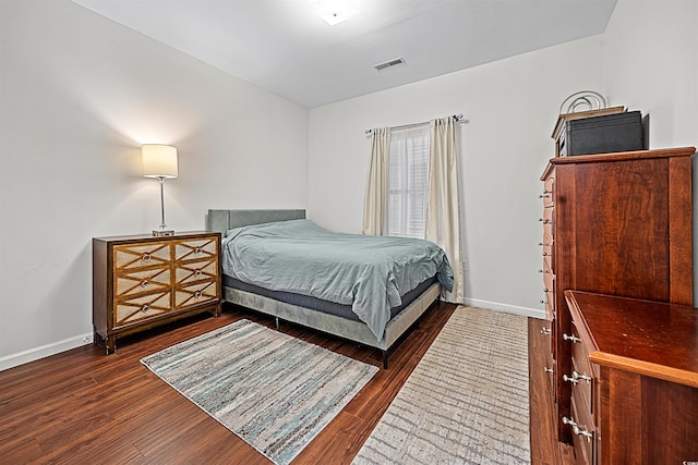 bedroom with dark hardwood / wood-style flooring