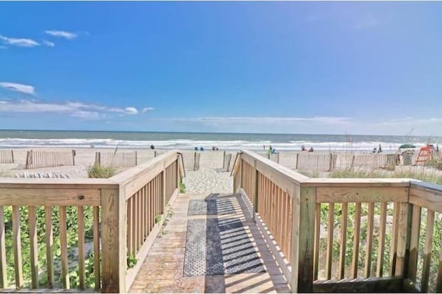 view of community featuring a water view and a beach view