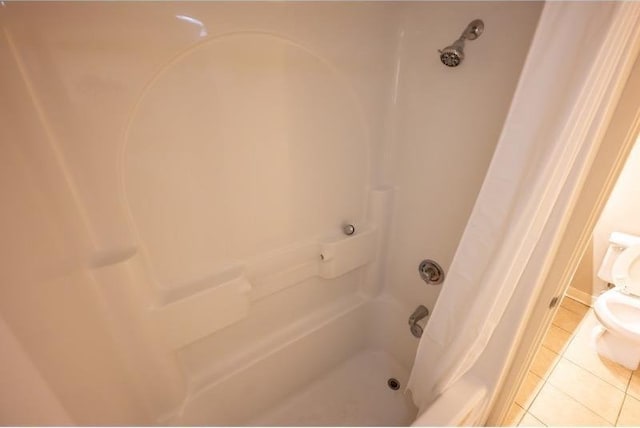 bathroom with a shower with curtain, tile patterned flooring, and toilet