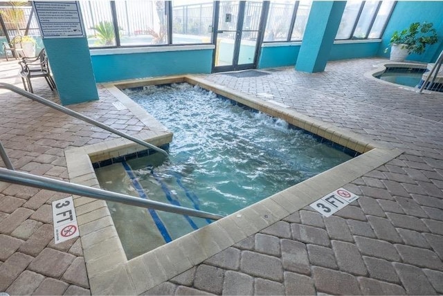 view of swimming pool featuring an indoor hot tub