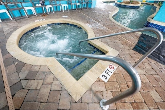 view of pool with a hot tub