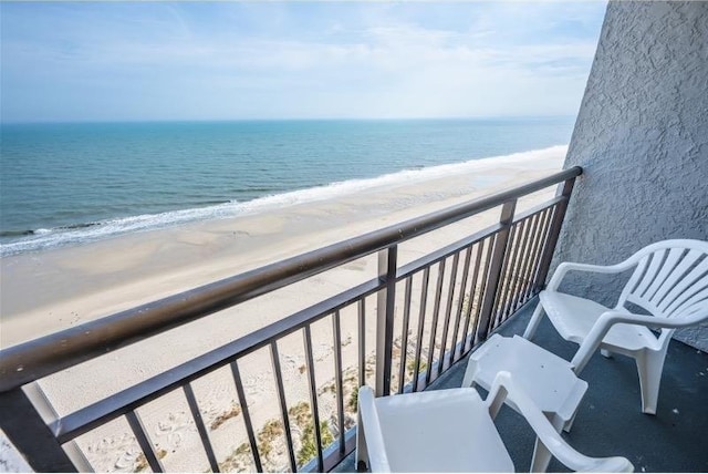 balcony featuring a view of the beach and a water view