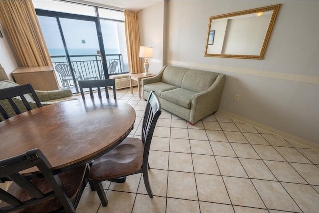 dining room featuring light tile patterned floors, a water view, and expansive windows