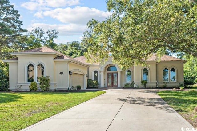 mediterranean / spanish-style house featuring a garage and a front yard