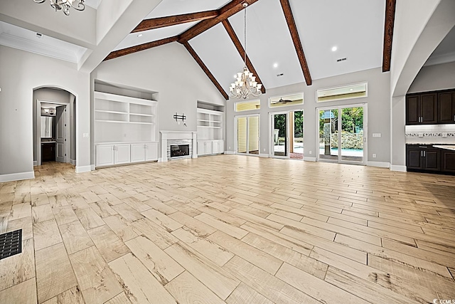 unfurnished living room featuring beamed ceiling, light wood-type flooring, a notable chandelier, built in shelves, and high vaulted ceiling