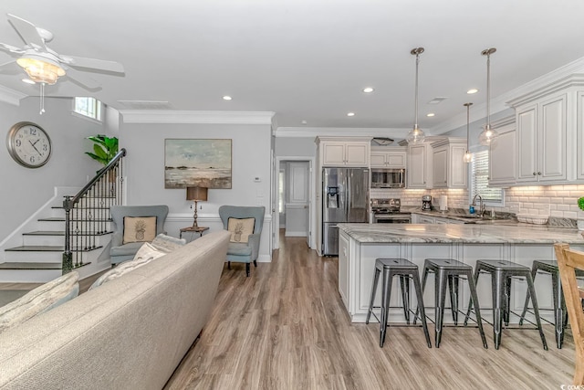 kitchen featuring decorative light fixtures, light hardwood / wood-style floors, plenty of natural light, and stainless steel appliances