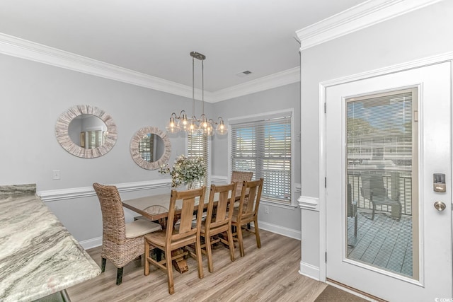 dining area featuring a chandelier, ornamental molding, and light wood-type flooring