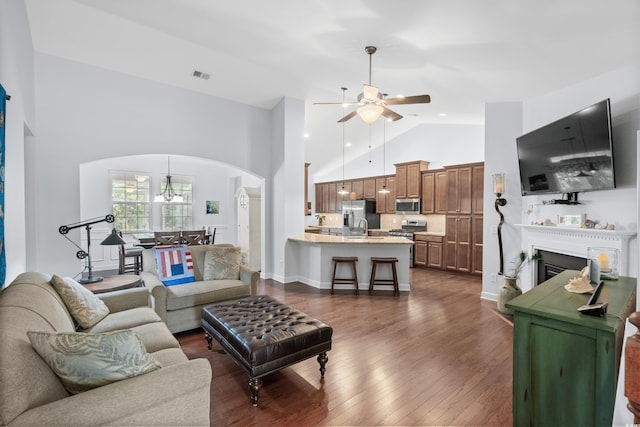 1433 Beaumont Way, Myrtle Beach, SC 29577 - living room with arched walkways, ceiling fan, high vaulted ceiling, dark wood-style floors, and a fireplace