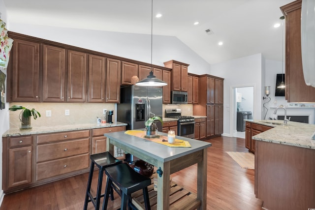 1433 Beaumont Way, Myrtle Beach, SC 29577 - kitchen featuring appliances with stainless steel finishes, a sink, decorative backsplash, high vaulted ceiling, and decorative light fixtures
