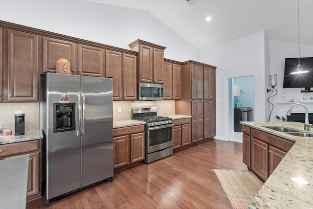 1433 Beaumont Way, Myrtle Beach, SC 29577 - kitchen featuring appliances with stainless steel finishes, a sink, high vaulted ceiling, decorative backsplash, and light stone counters