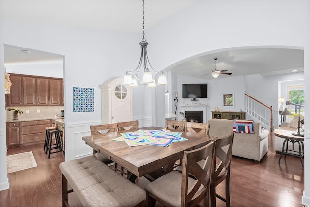 1433 Beaumont Way, Myrtle Beach, SC 29577 - dining space featuring ceiling fan, high vaulted ceiling, a fireplace, arched walkways, and dark wood-type flooring