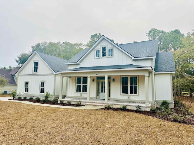 modern inspired farmhouse with a porch and a front lawn