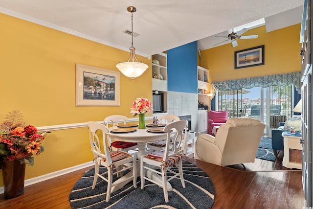dining room featuring ornamental molding, built in features, wood finished floors, baseboards, and a ceiling fan