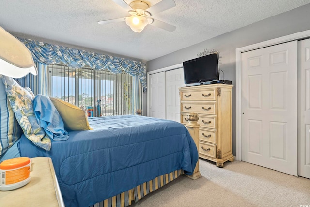 bedroom featuring a textured ceiling, ceiling fan, light carpet, and access to exterior