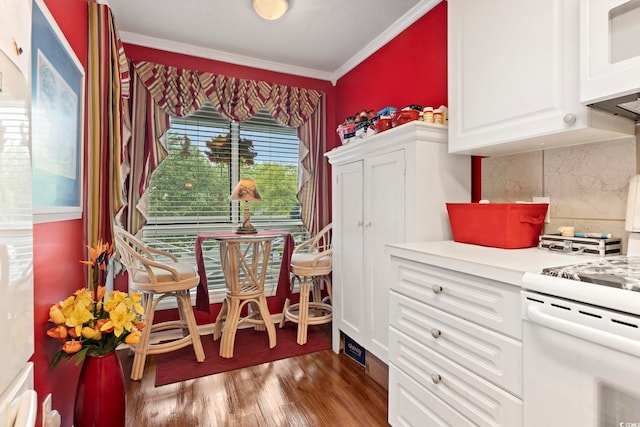 interior space with white cabinets, tasteful backsplash, dark hardwood / wood-style flooring, ornamental molding, and white range