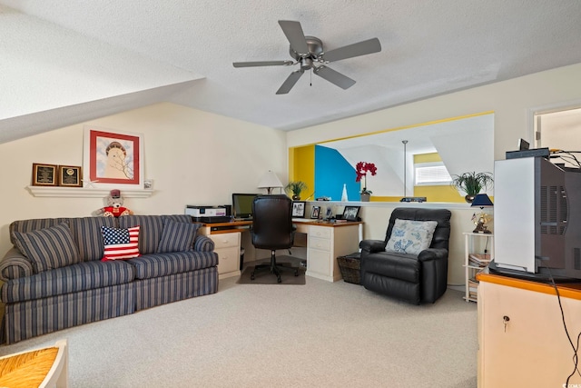 carpeted office space with built in desk, vaulted ceiling, a textured ceiling, and ceiling fan