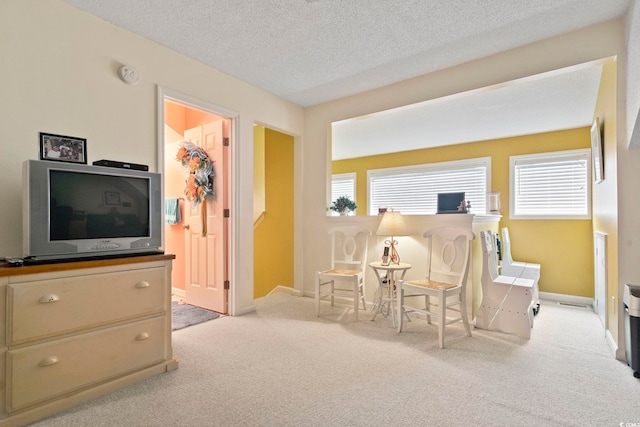 sitting room featuring plenty of natural light, carpet flooring, a textured ceiling, and baseboards