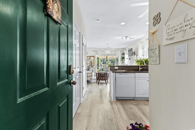 entrance foyer with a textured ceiling, light hardwood / wood-style floors, and sink