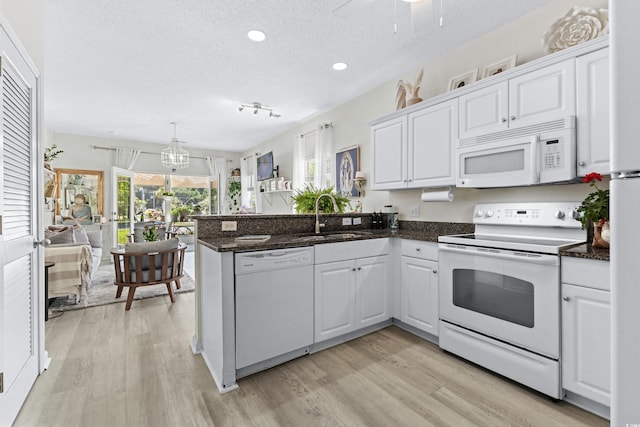 kitchen featuring white cabinets, white appliances, and kitchen peninsula