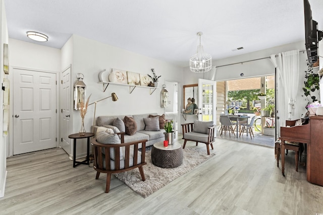 living room featuring light hardwood / wood-style floors and an inviting chandelier