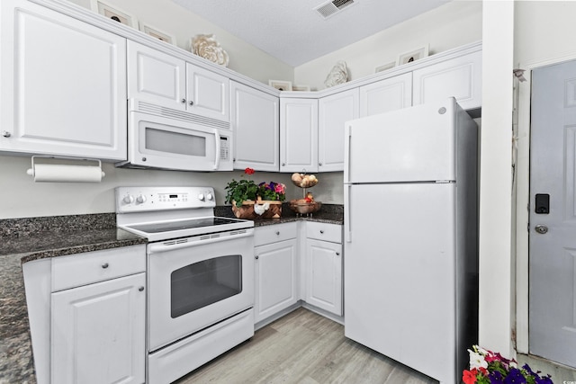 kitchen with a textured ceiling, white appliances, light hardwood / wood-style flooring, dark stone countertops, and white cabinetry