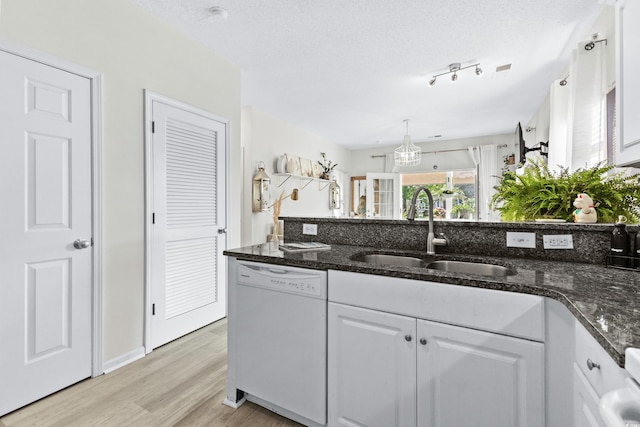 242 Sun Colony Blvd Unit 101, Longs, SC 29568 - kitchen with white dishwasher, light wood-style flooring, white cabinetry, dark stone countertops, and a textured ceiling