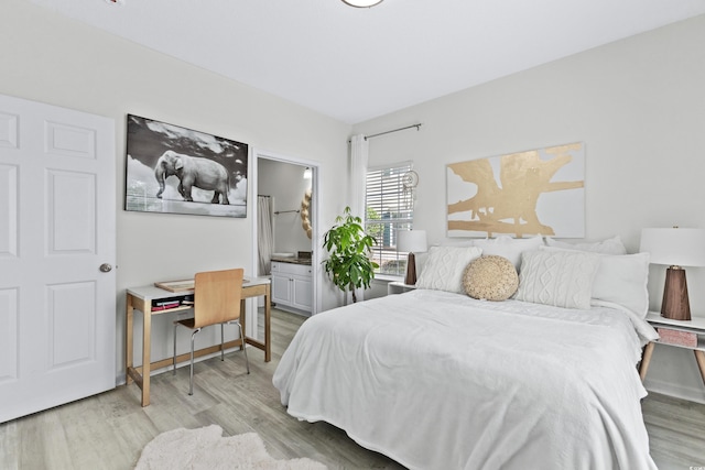 bedroom with connected bathroom and light hardwood / wood-style flooring