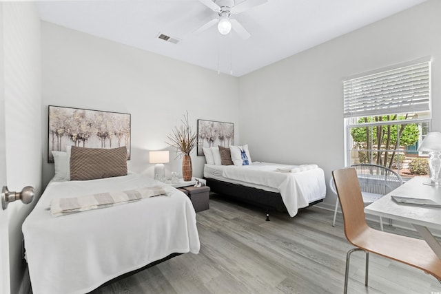 bedroom with wood-type flooring, access to outside, and ceiling fan