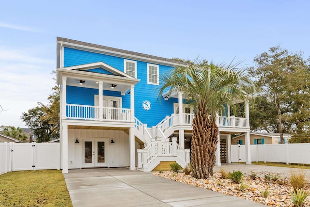 coastal inspired home featuring covered porch and french doors