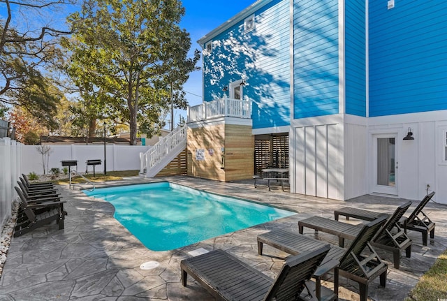 view of pool with a fenced backyard, a fenced in pool, stairs, and a patio area