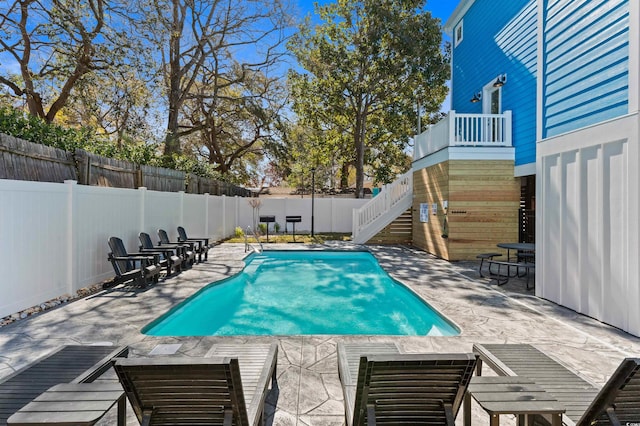 view of pool featuring a fenced backyard, a patio, stairway, and a fenced in pool