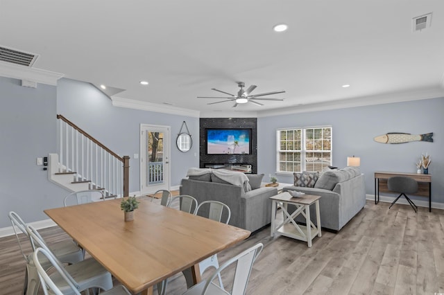 dining area featuring visible vents, crown molding, and light wood-type flooring