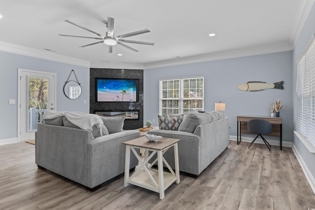living room featuring wood finished floors, crown molding, and plenty of natural light