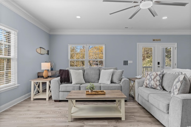 living room featuring light wood finished floors, baseboards, ornamental molding, and a ceiling fan