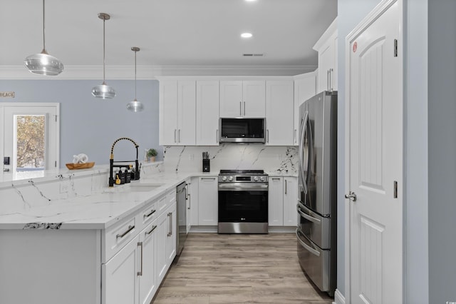 kitchen with white cabinetry, ornamental molding, backsplash, a sink, and appliances with stainless steel finishes