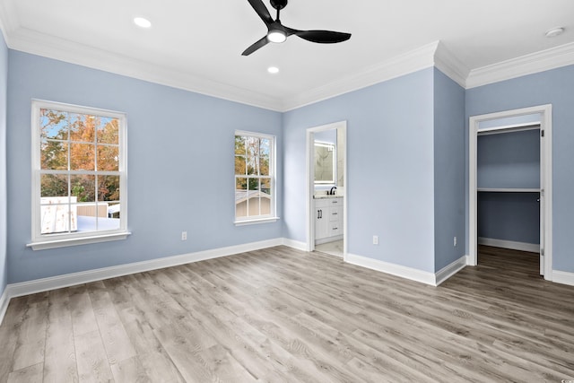 unfurnished bedroom featuring a walk in closet, ceiling fan, light hardwood / wood-style flooring, connected bathroom, and a closet