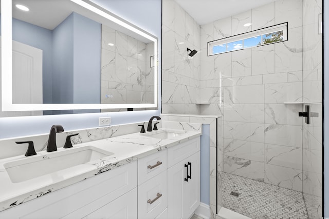 bathroom with tiled shower and vanity