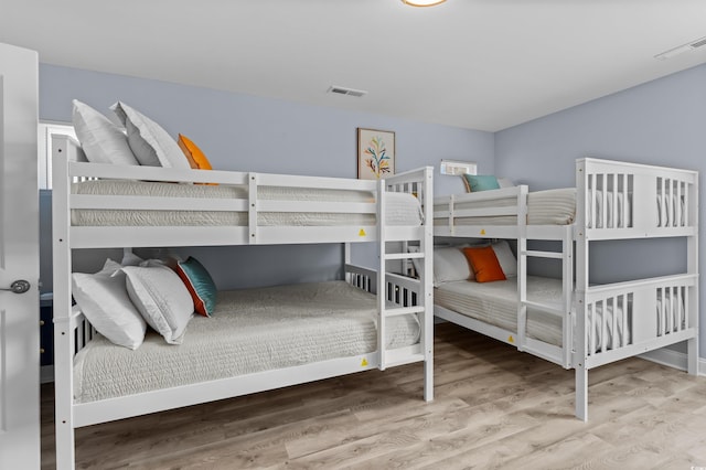 bedroom featuring wood finished floors and visible vents