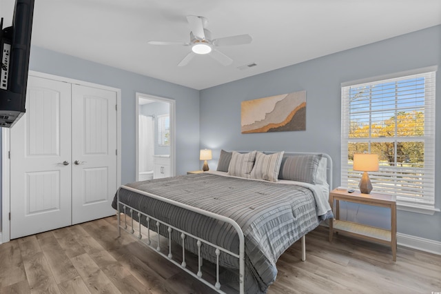 bedroom featuring multiple windows, a closet, light wood finished floors, and visible vents
